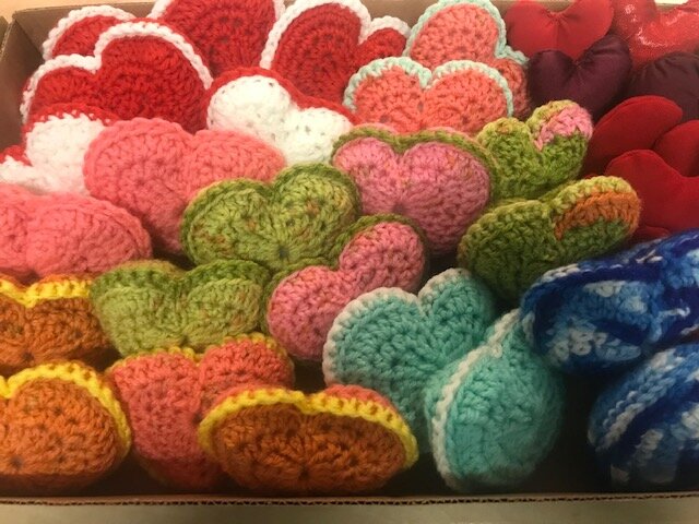 A colourful set of sewn, knitted or crocheted hearts