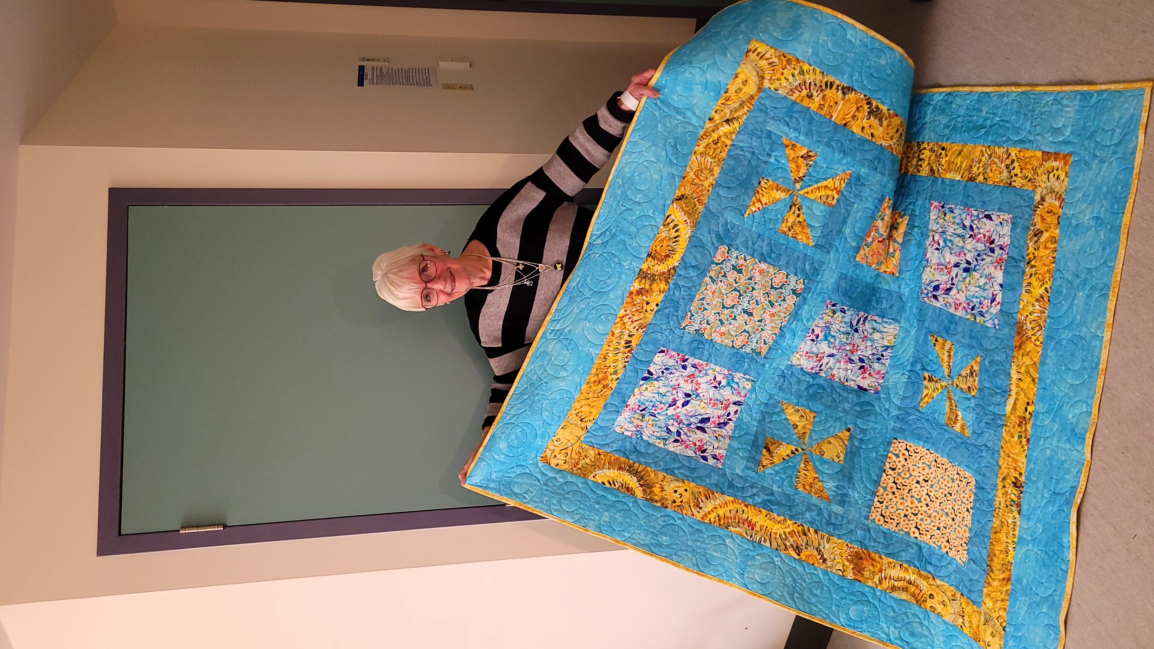 Linda Schmidt receives a handmade quilt from Blankets of Love program