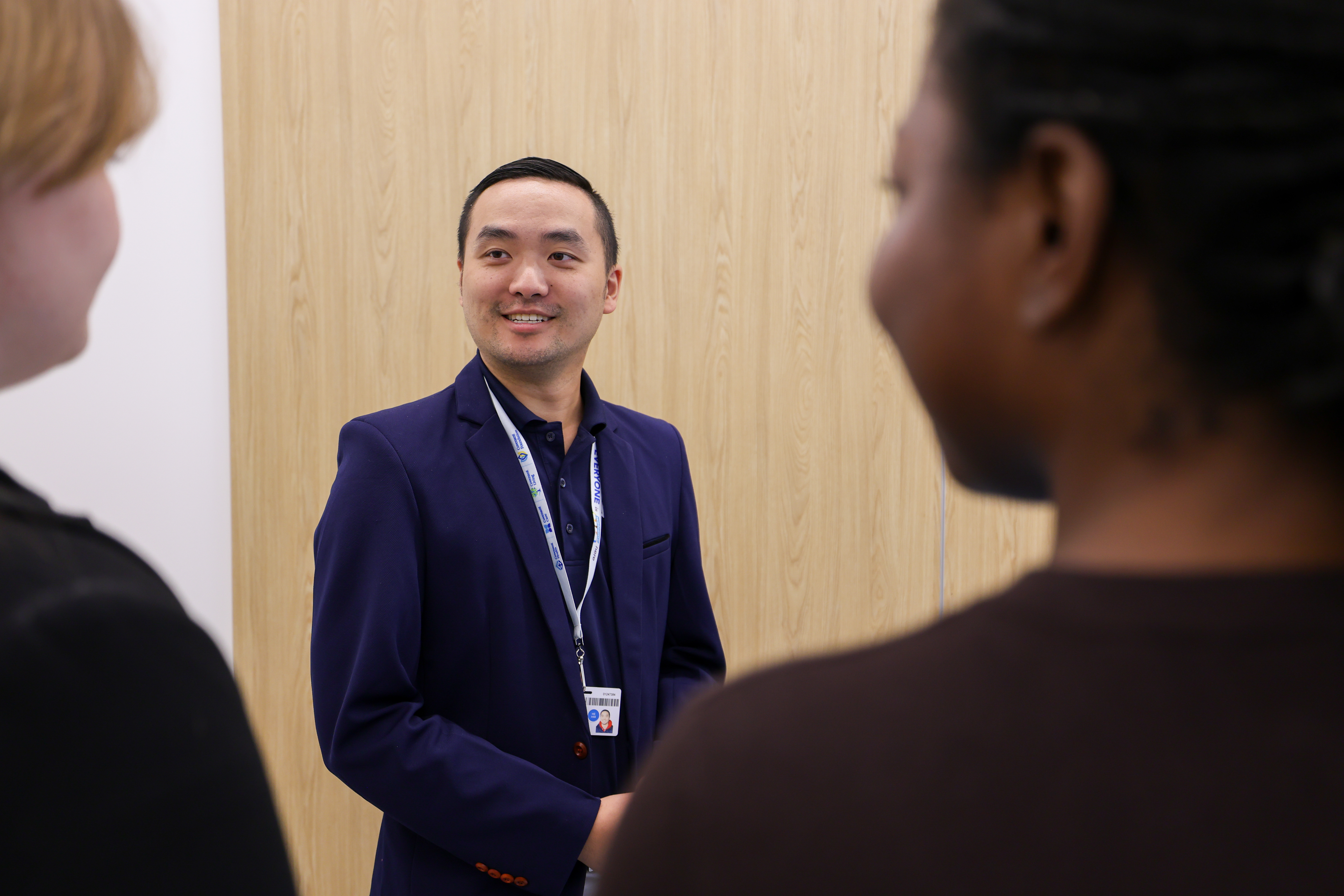 Brandon Wong speaking to post-secondary students about health care career options at a career fair.