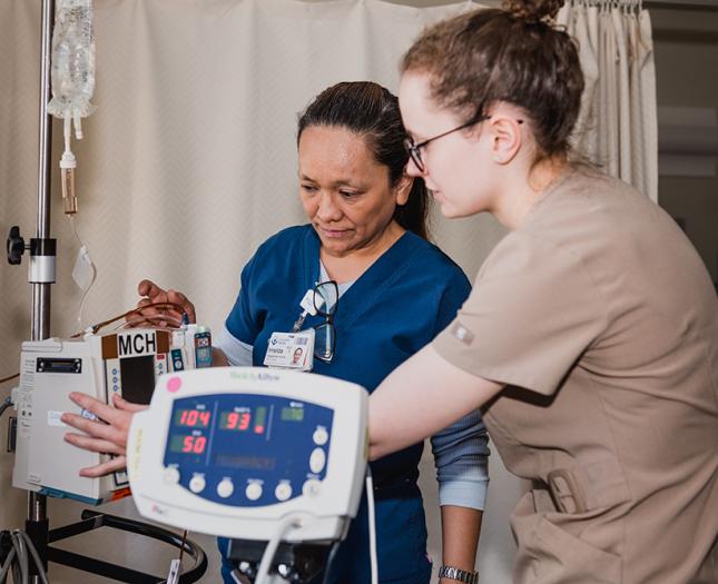 A Covenant Health staff member and student work together.