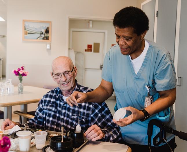 A staff member helps a resident during mealtime.