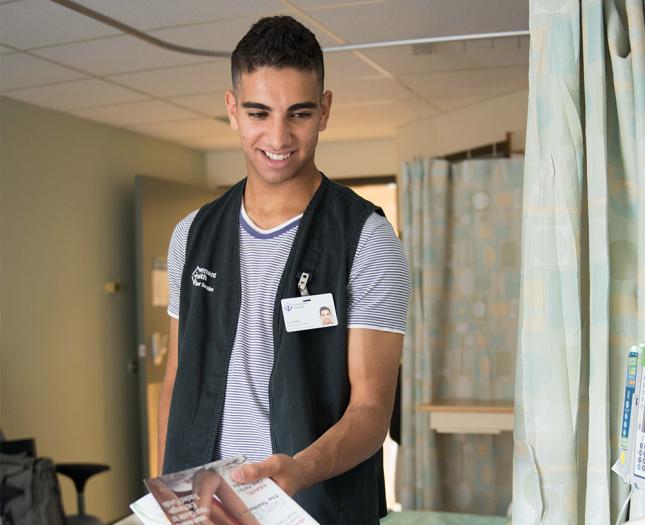 volunteers-what-to-expect-hero A volunteer hands a patient a magazine