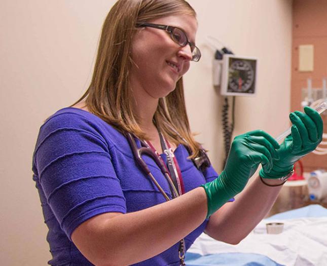 A staff member with a stethoscope smiles as she works