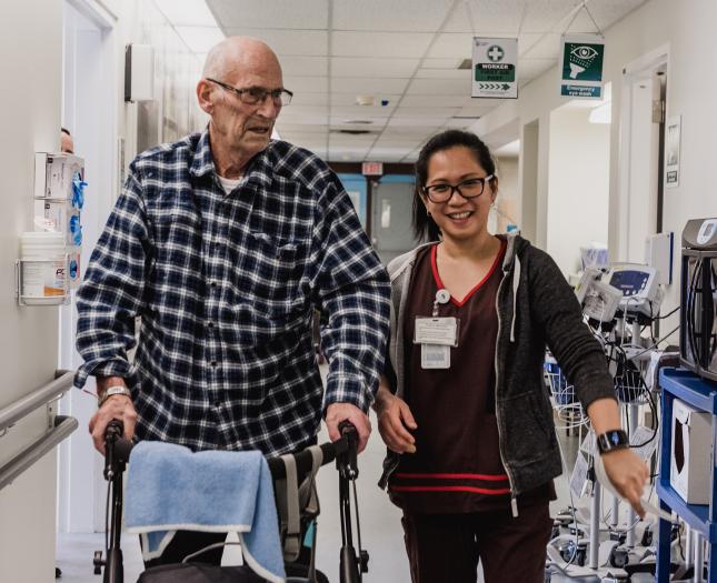 Hiring rehabilitation medicine practitioners Rehab medicine professional helps a patient during a walk.
