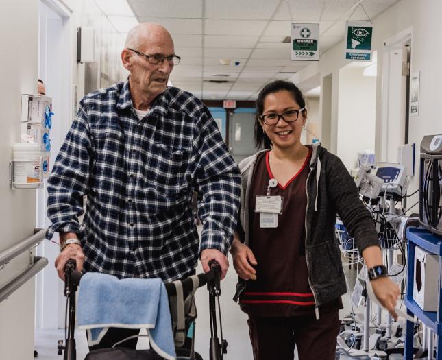 Rehab medicine professional helps a patient during a walk.