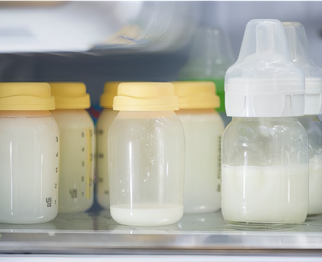 Bottles of expressed breast milk on a fridge shelf