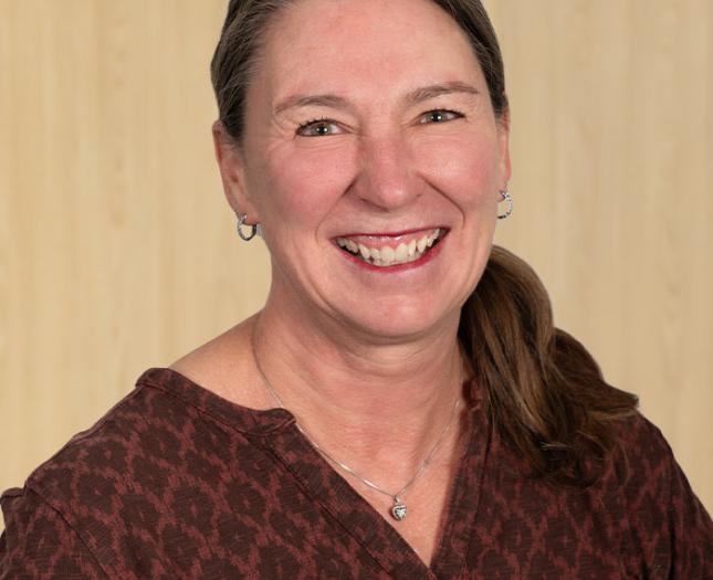 Headshot of Sheri Allen in a natural wood background