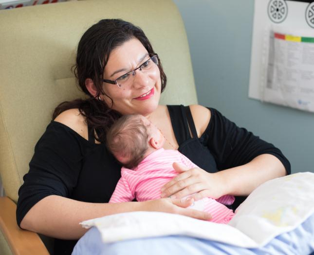 woman hugging newborn baby