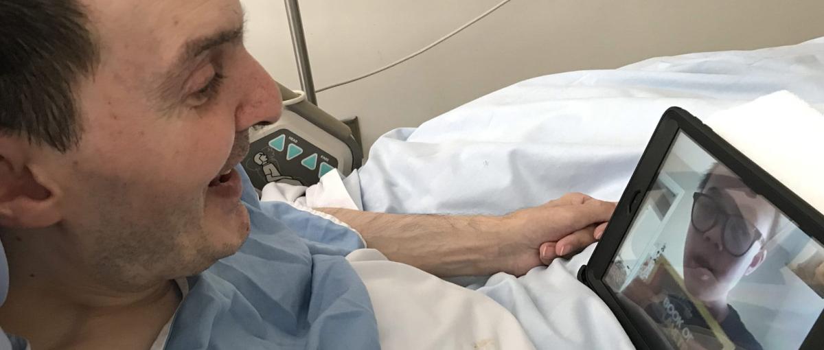 A patient talks to a Covenant Health volunteer over Skype on a tablet computer