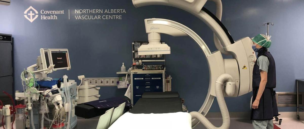 A masked healthcare worker in an operating room of the Northern Alberta Vascular Centre