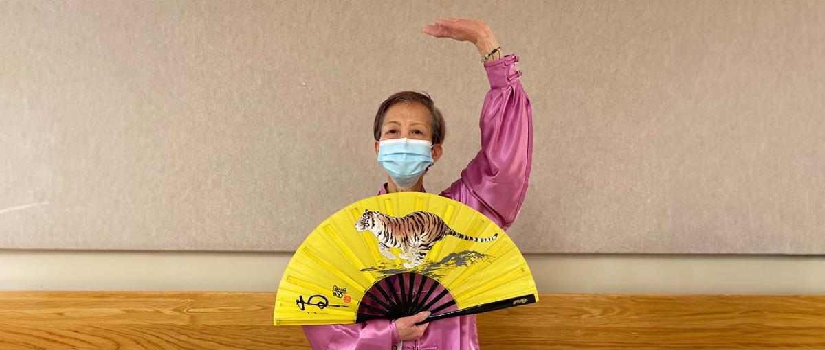 King demonstrates Tai Chi while wearing traditional dress.