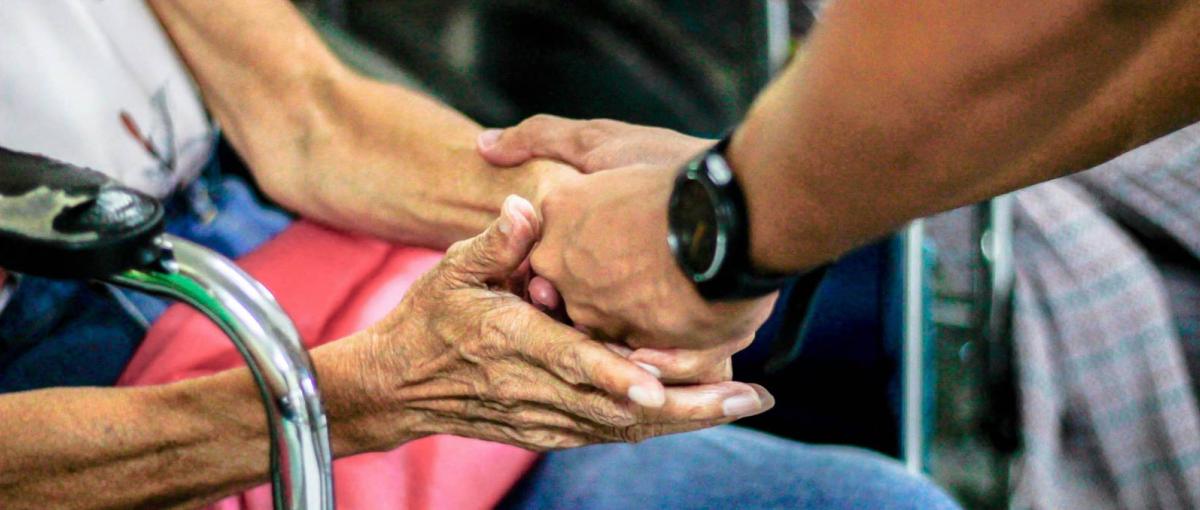 Elderly hands and young hands holding each other