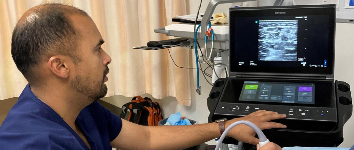 A doctor looks at a screen depicting a patient's ultrasound vein mapping