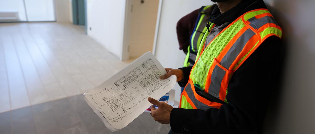 A contractor shares a blueprint of the Covenant Wellness Community - Lakewood in southeast Edmonton.
