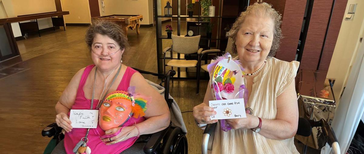 Residents at St. Teresa Place in Calgary show the masks they made in creative arts program.