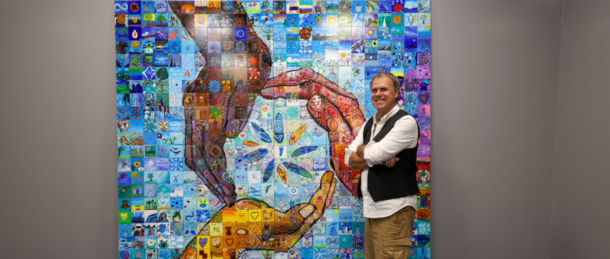 Artist Lewis Lavoie shows off the mural mosaic installed at the Lakewood Community Health Centre in Mill Woods..