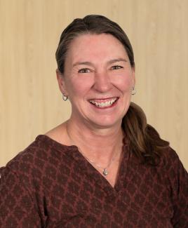 Headshot of Sheri Allen in a natural wood background
