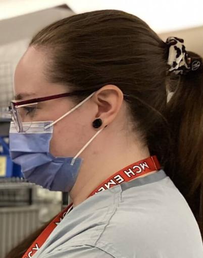 A licensed practical nurse looks into the screen of a heart rate monitor