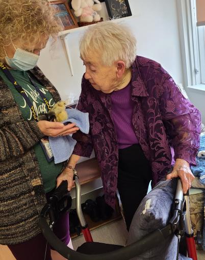 Randi holds a chick in her hands for a resident to see.