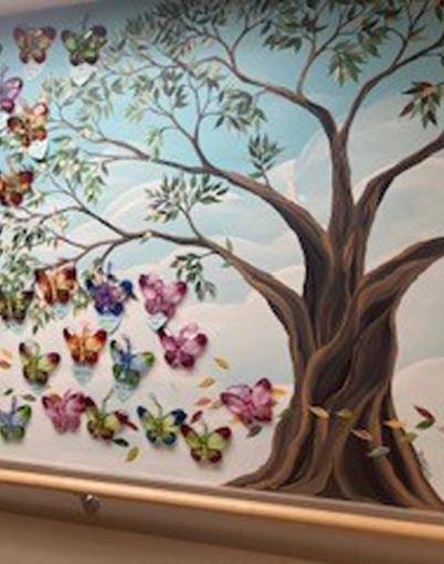 Painted mural of a tree and a kaleidoscope of butterflies