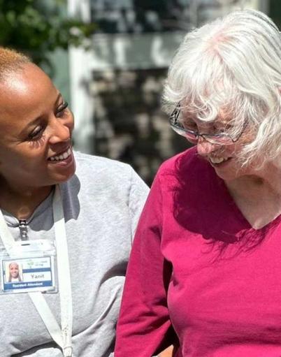 Health care aide walking with a senior