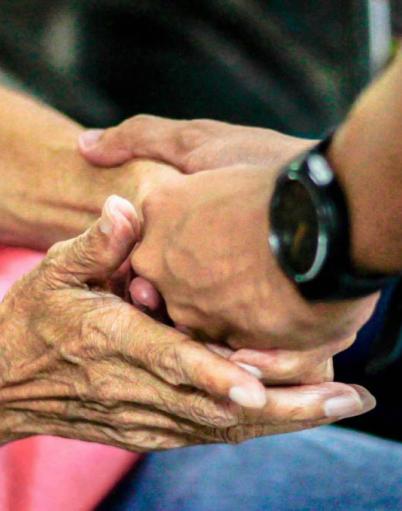 Elderly hands and young hands holding each other