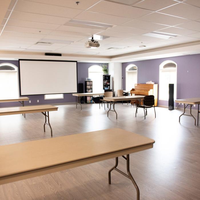 Recreation room with tables, chairs and large windows