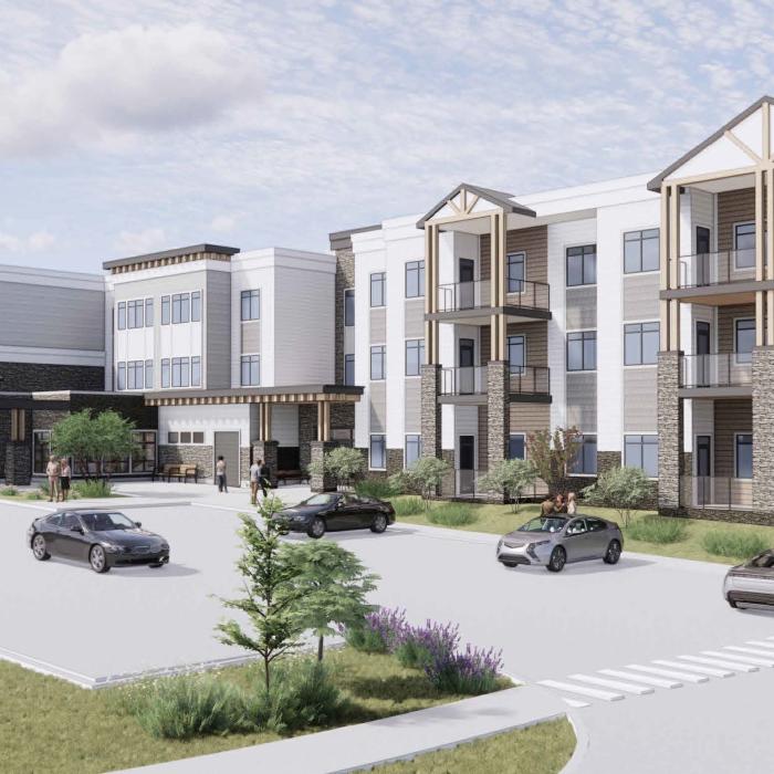 Exterior view of Trochu Supportive Living facility with parking lot, cars, and landscaped greenery.