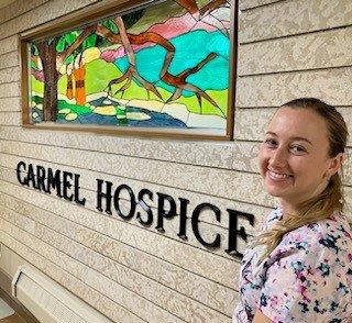 Christina poses near a stained glass window on Carmel Hospice.