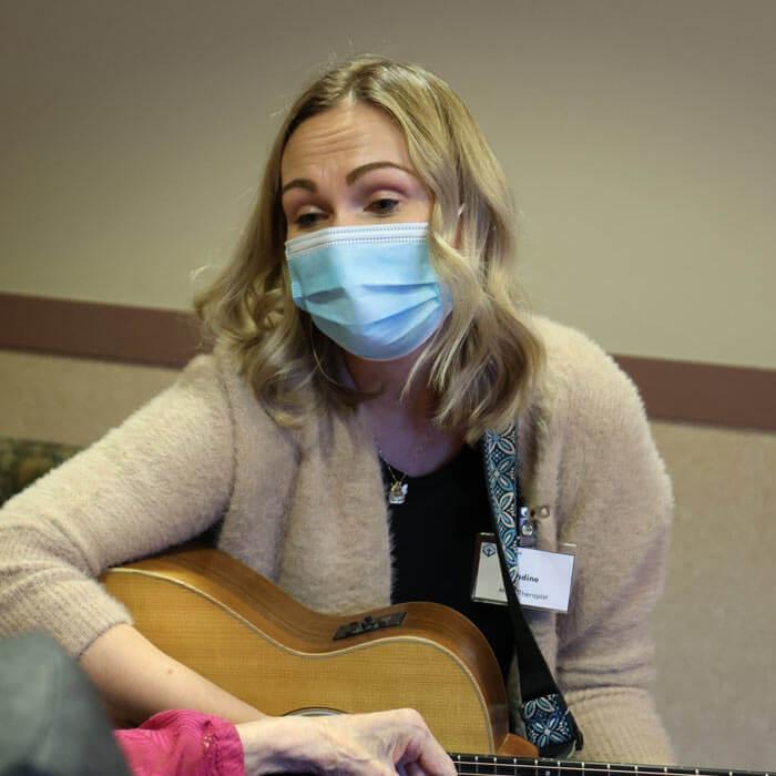 Nadine Verboa plays on her guitar for a resident