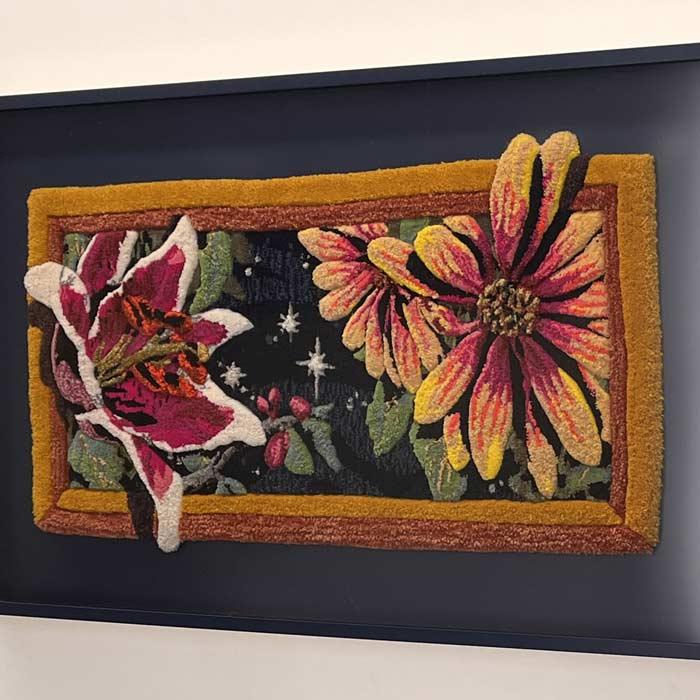 Artwork depicting stargazer lilies and asters created from yarn