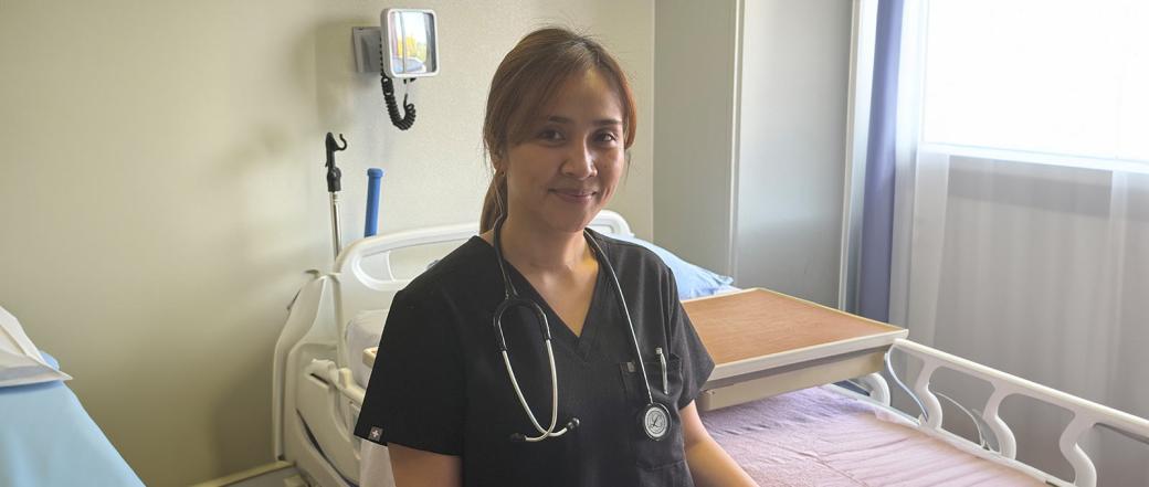 Internationally educated nurse Keren Balagot poses at bedside at St. Mary’s Hospital in Camrose, Alberta.