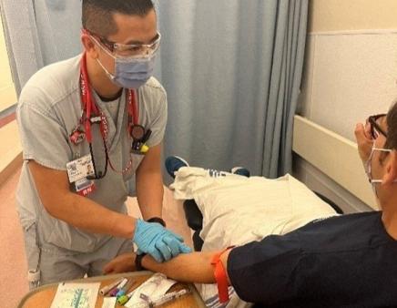 Jason takes a blood sample from a patient in the emergency department.