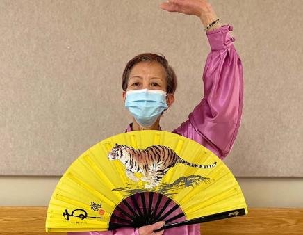 King demonstrates Tai Chi while wearing traditional dress.